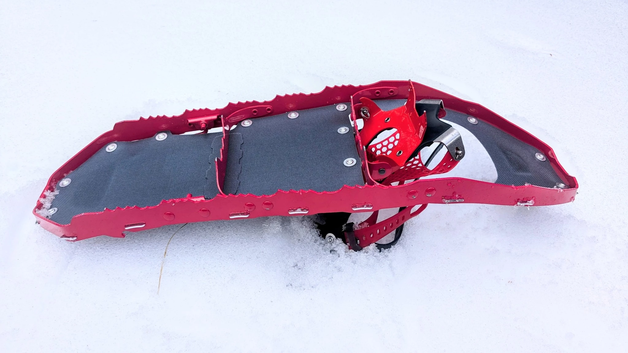 Close-up of the metal teeth and traction rails on the frame of an MSR Lightning Ascent snowshoe.