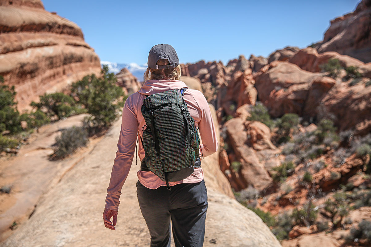 A hiker wearing the REI Flash 22 daypack during an outdoor excursion.