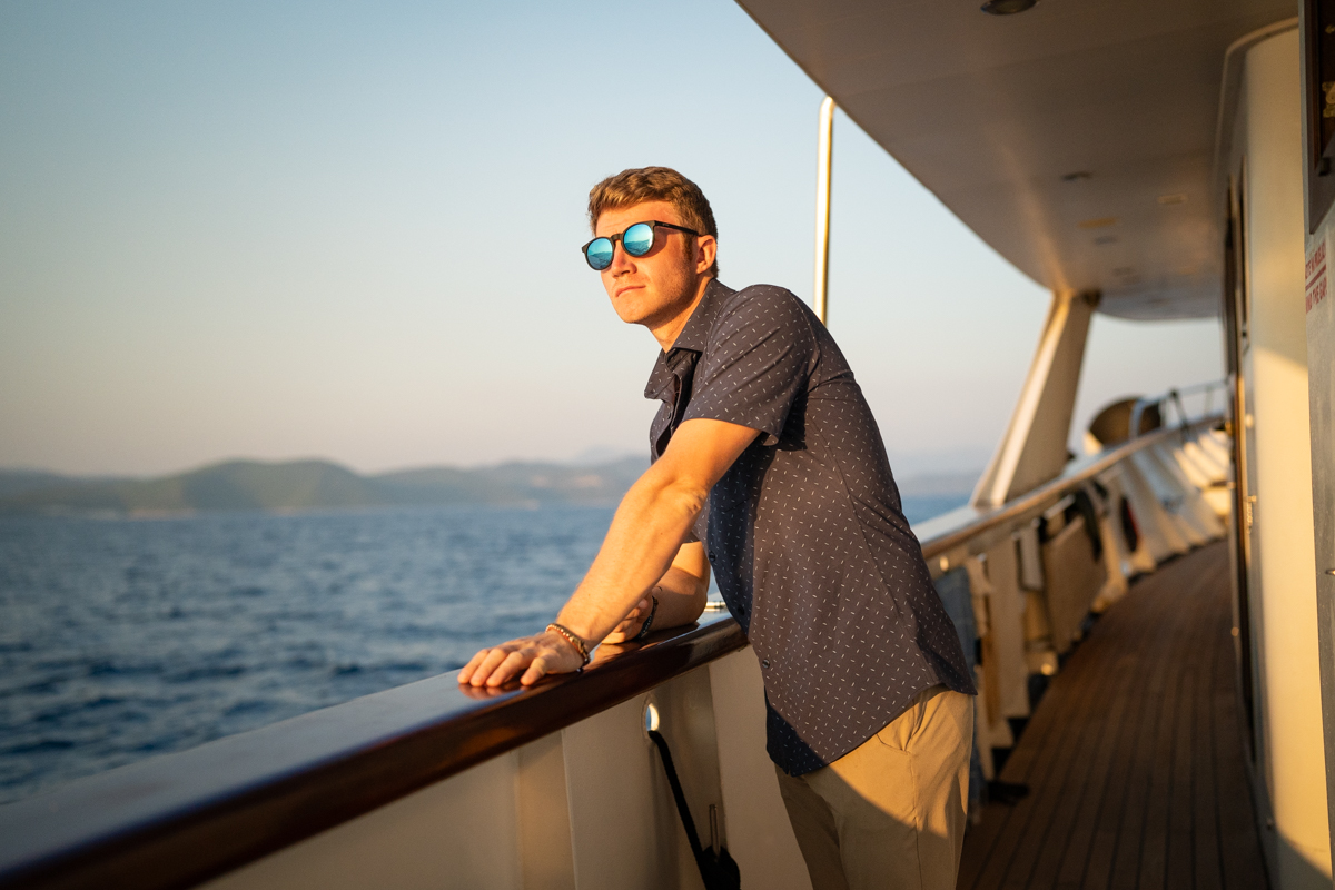 A person wearing lightweight Teren traveler pants on a boat in a sunny environment.