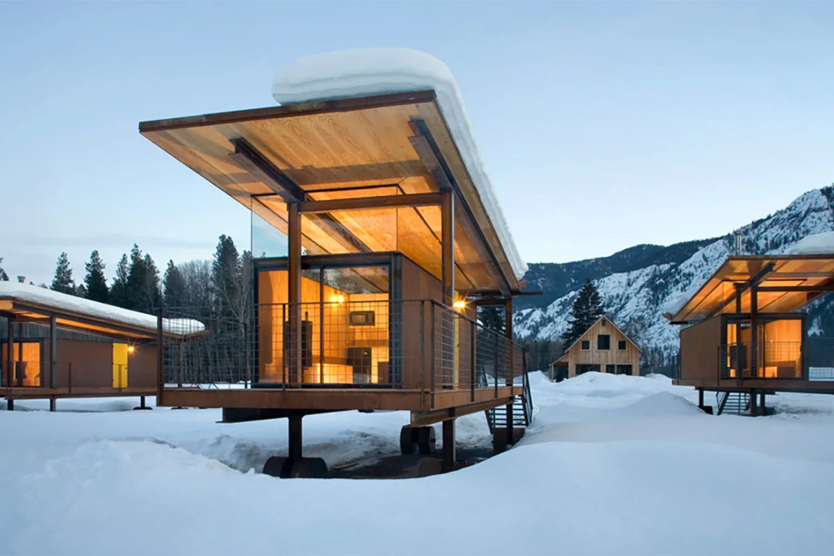 Modern, box-shaped Rolling Huts on wheels set against a mountain backdrop in Methow Valley.