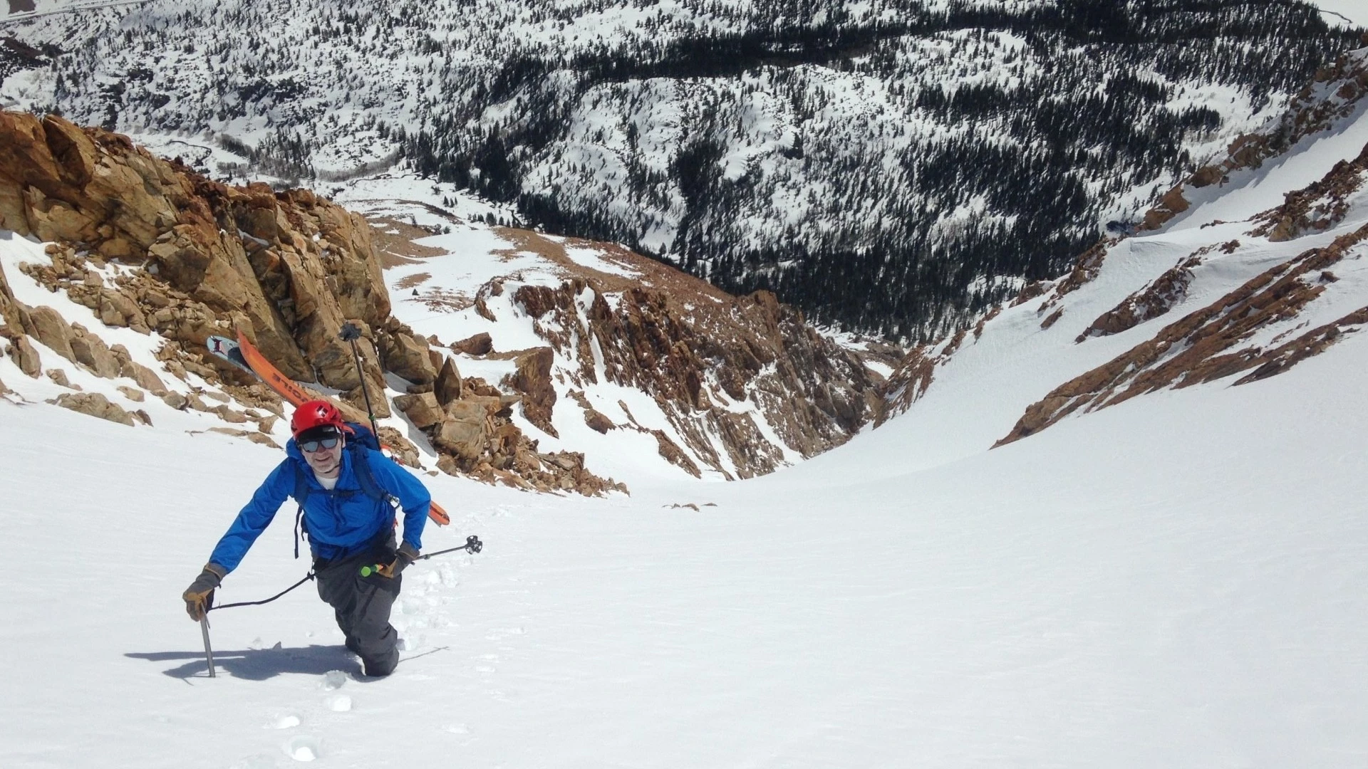 An alpine climber using a softshell jacket during a high-altitude mountain expedition.