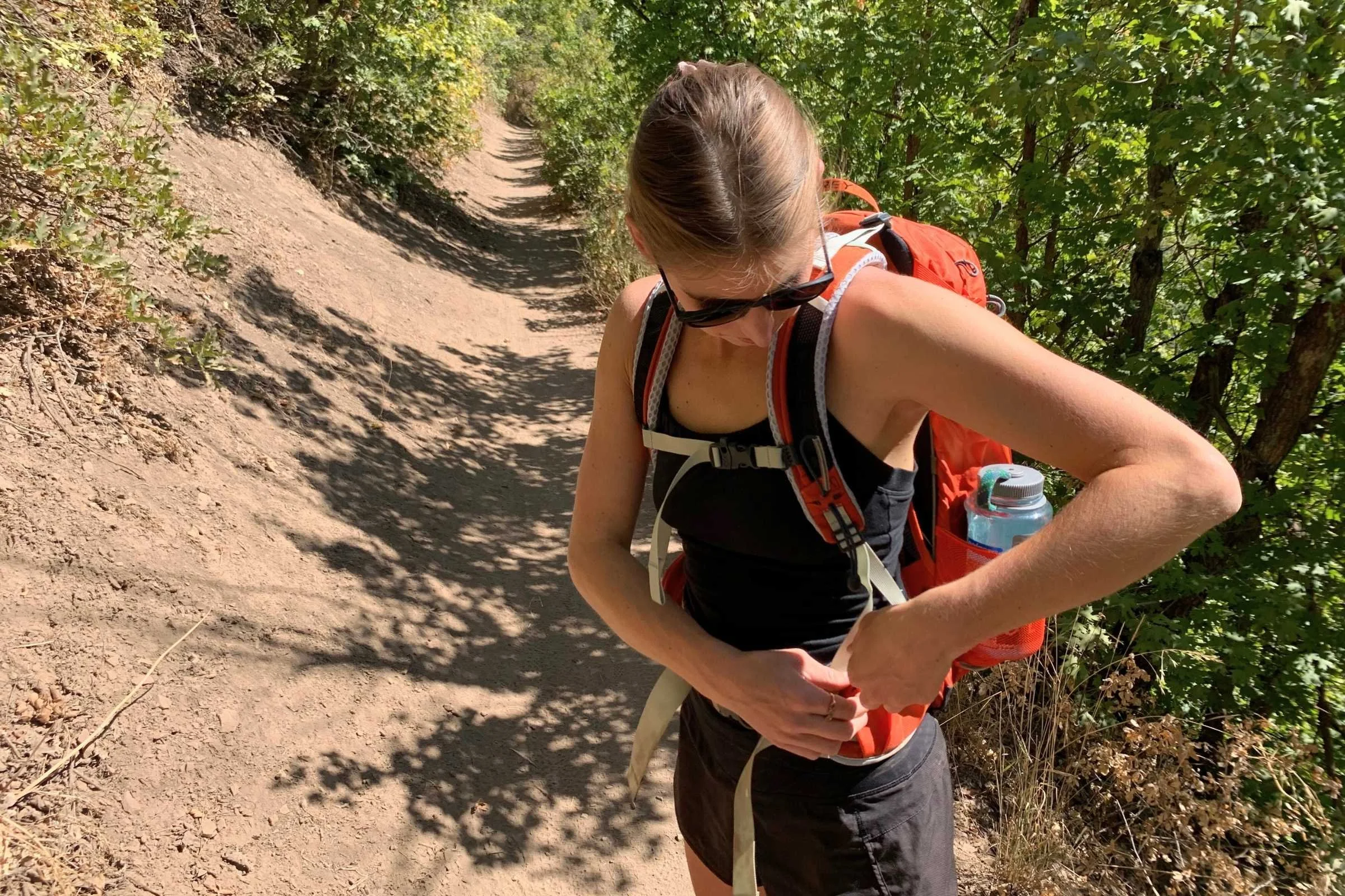 Close-up of a padded backpack hip belt fastened around a hiker's waist.