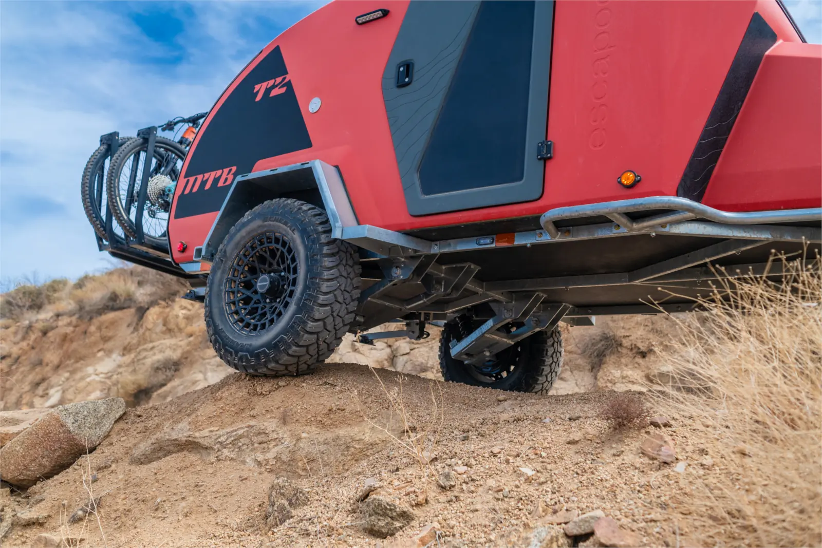 Escapod TOPO2 MTB trailer perched on a large rock to demonstrate high ground clearance.