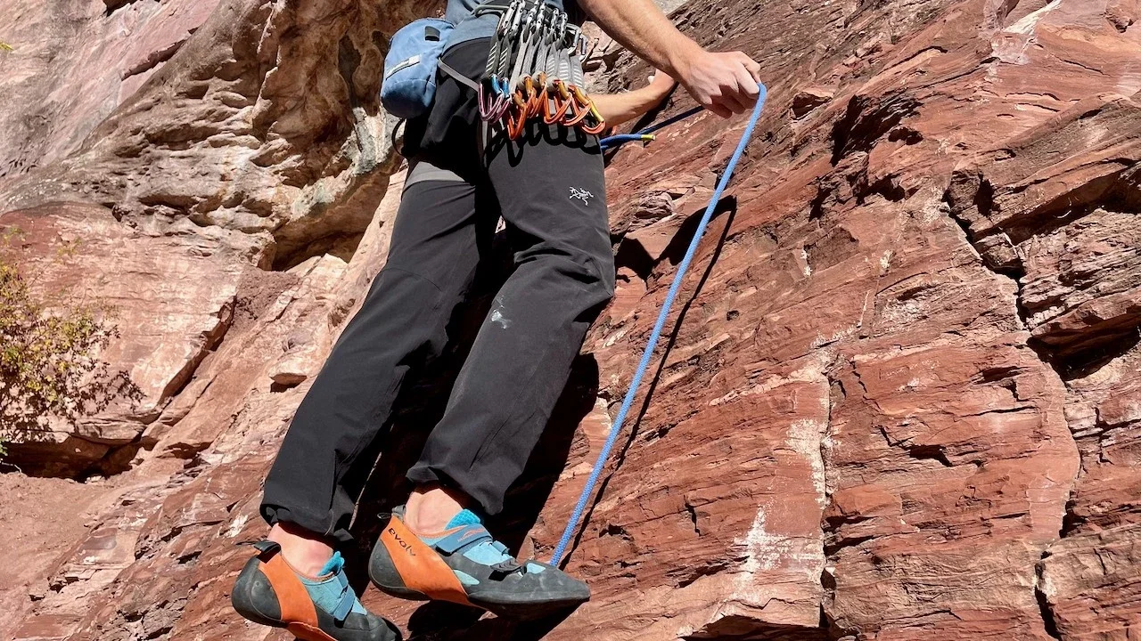 A person wearing Arc'teryx Gamma pants while climbing a rocky vertical section.