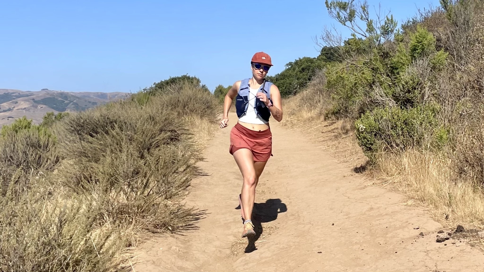 A runner testing performance shorts on a paved trail during a training session.