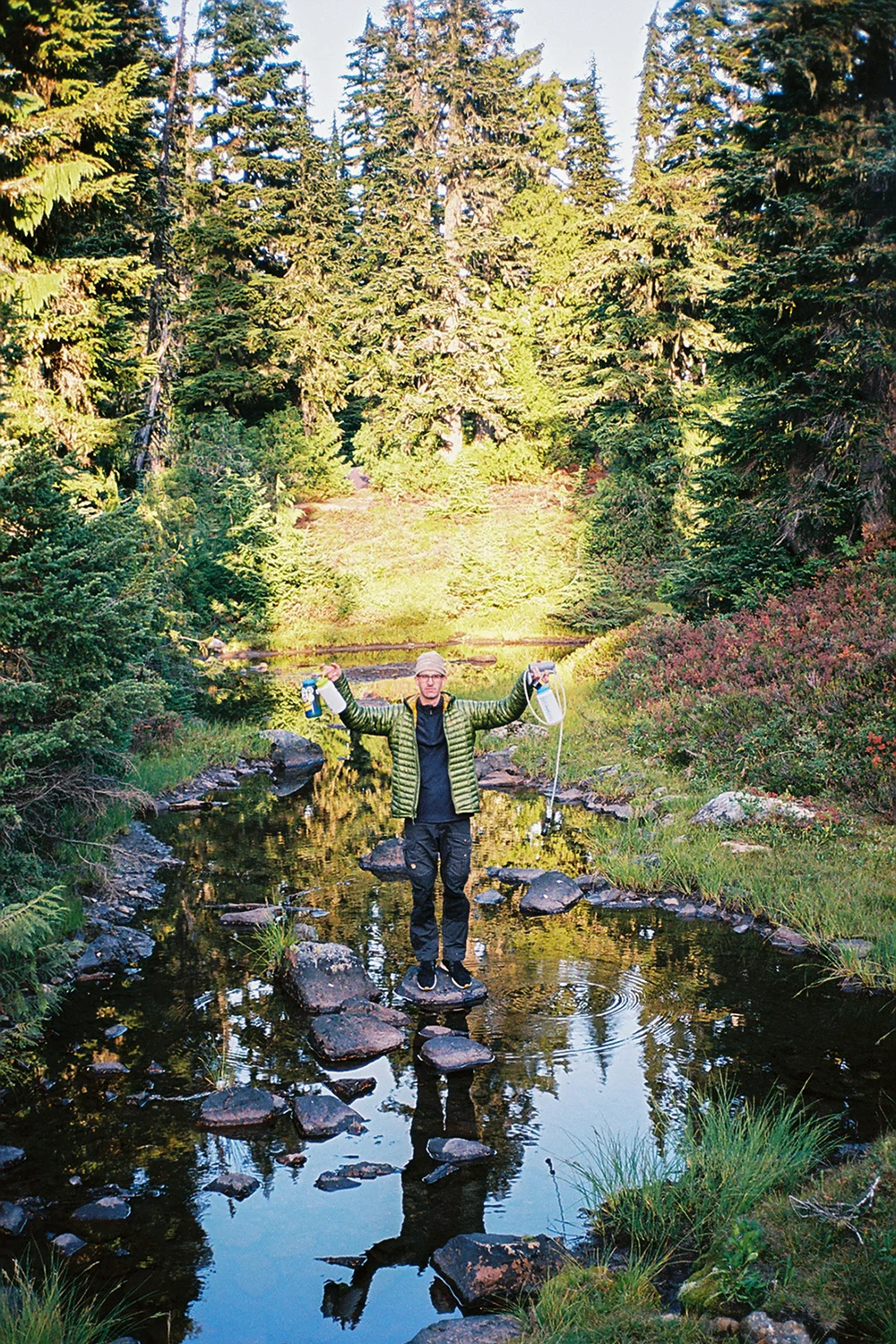 A hiker wearing water-resistant trousers while hiking near Mount Rainier in overcast weather.