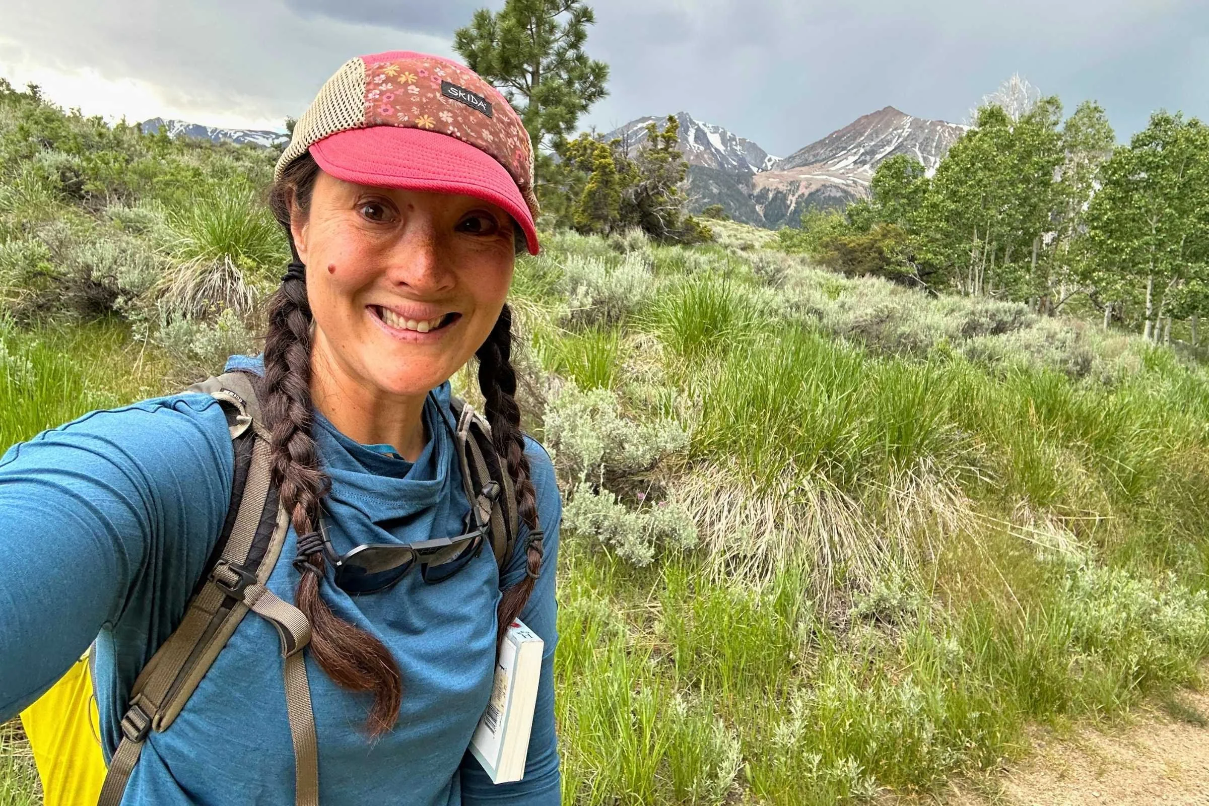 Liz Thomas hiking in the REI Flash Shade hoodie with a backpack.