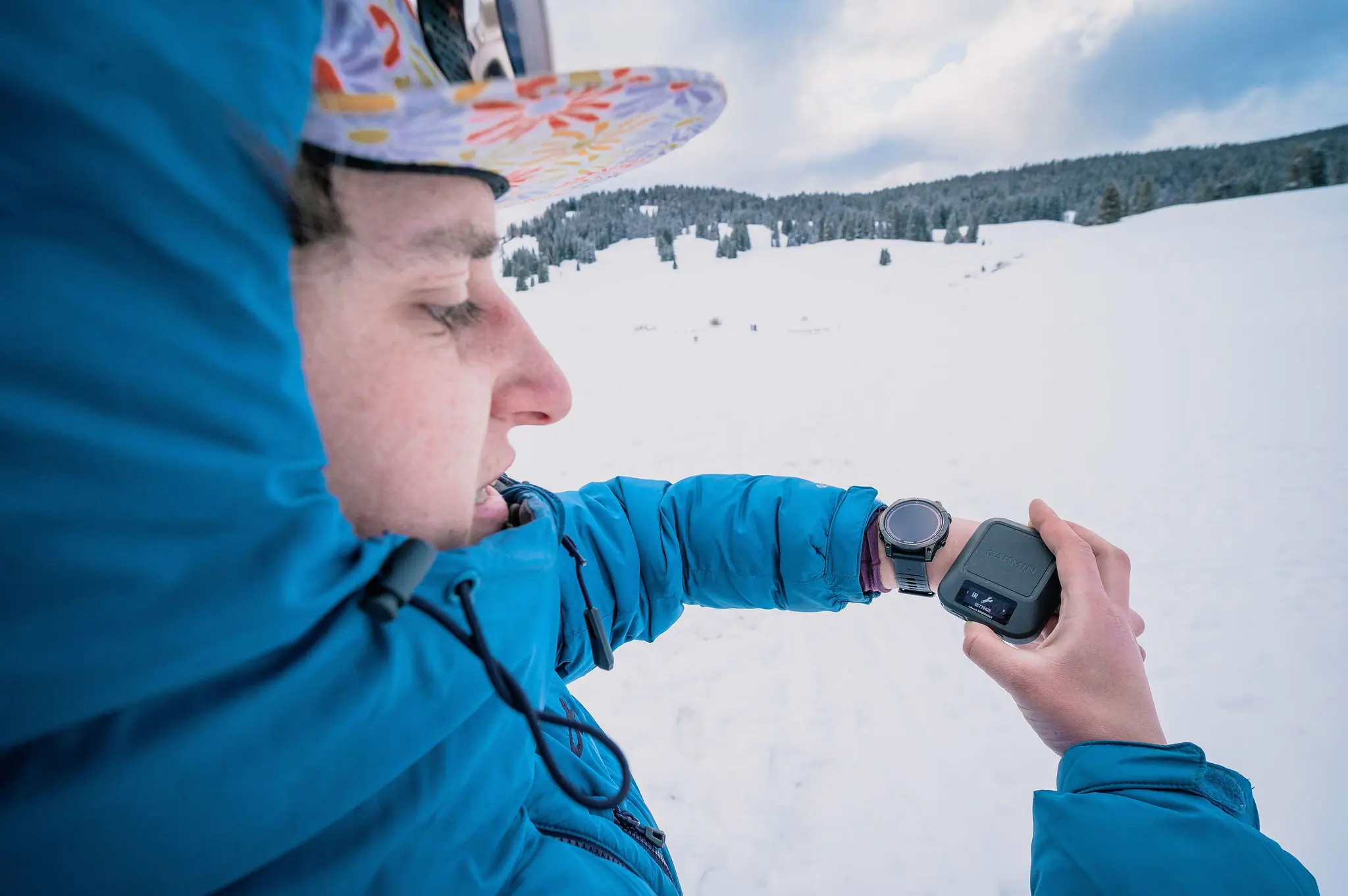 Multiple satellite messengers being tested for battery life on a snowy surface.