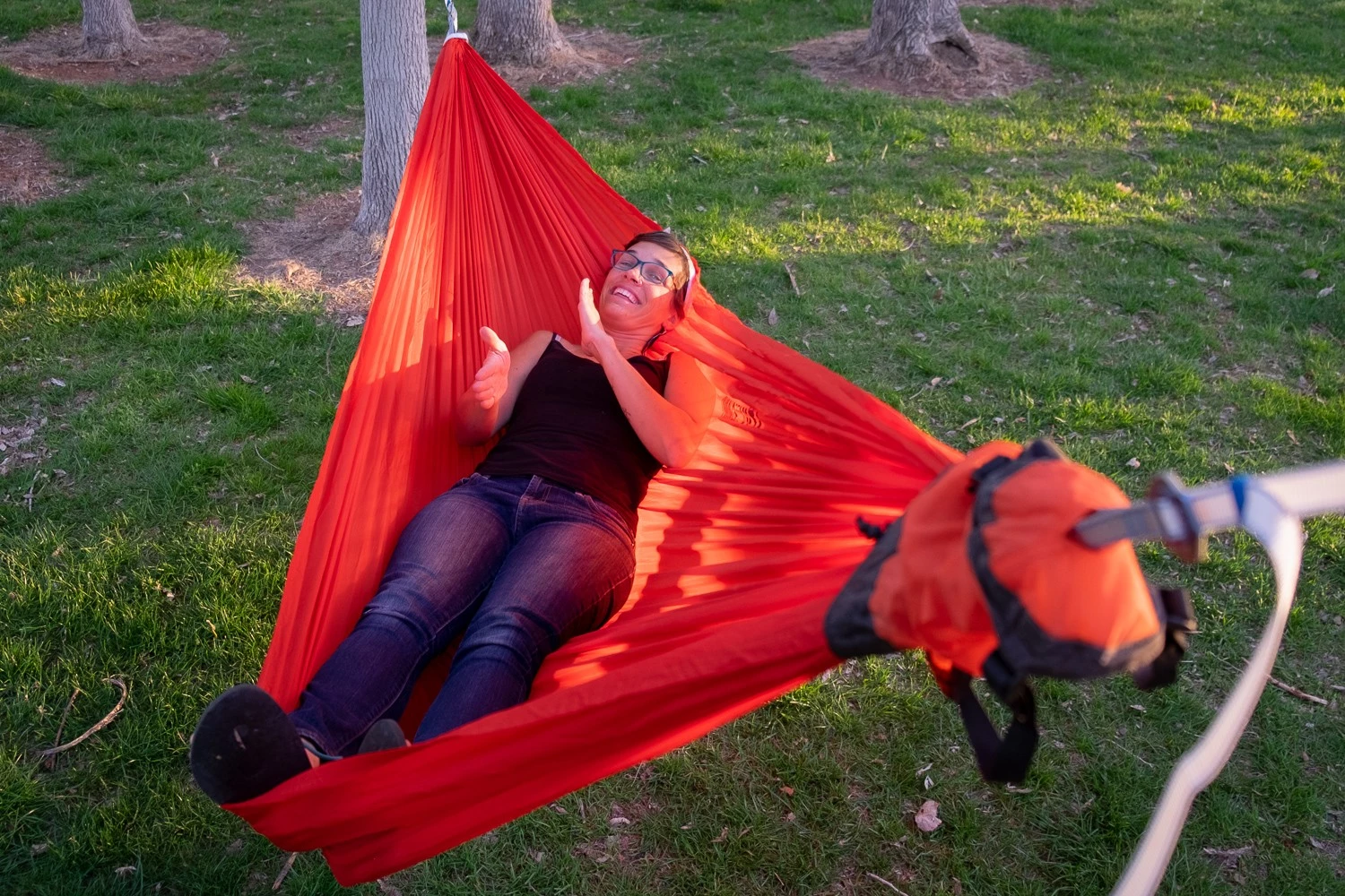 High-angle view of a person lying diagonally across a hammock to achieve a flat sleeping surface.