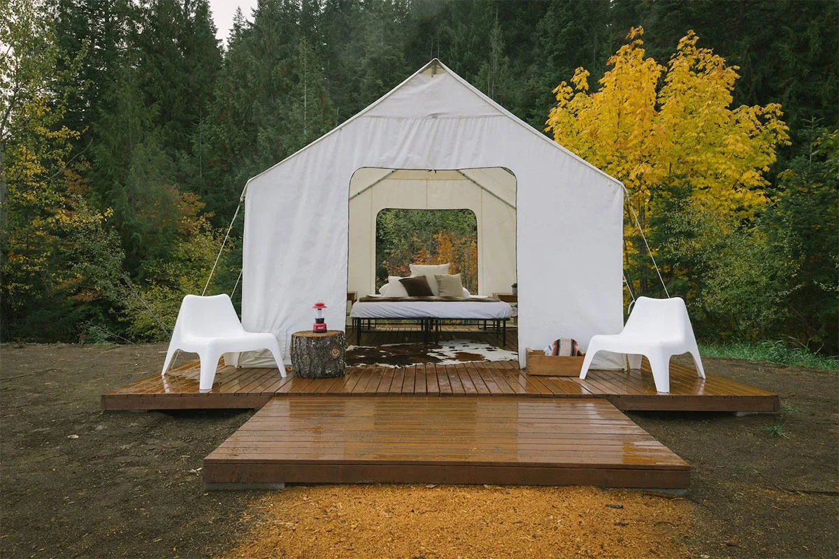 A large white glamping tent situated on a grassy field at Cave Creek Farm.