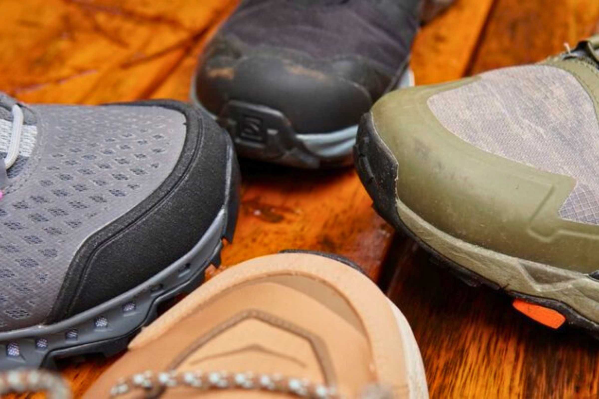 Close-up of different toe cap designs on four types of hiking shoes.