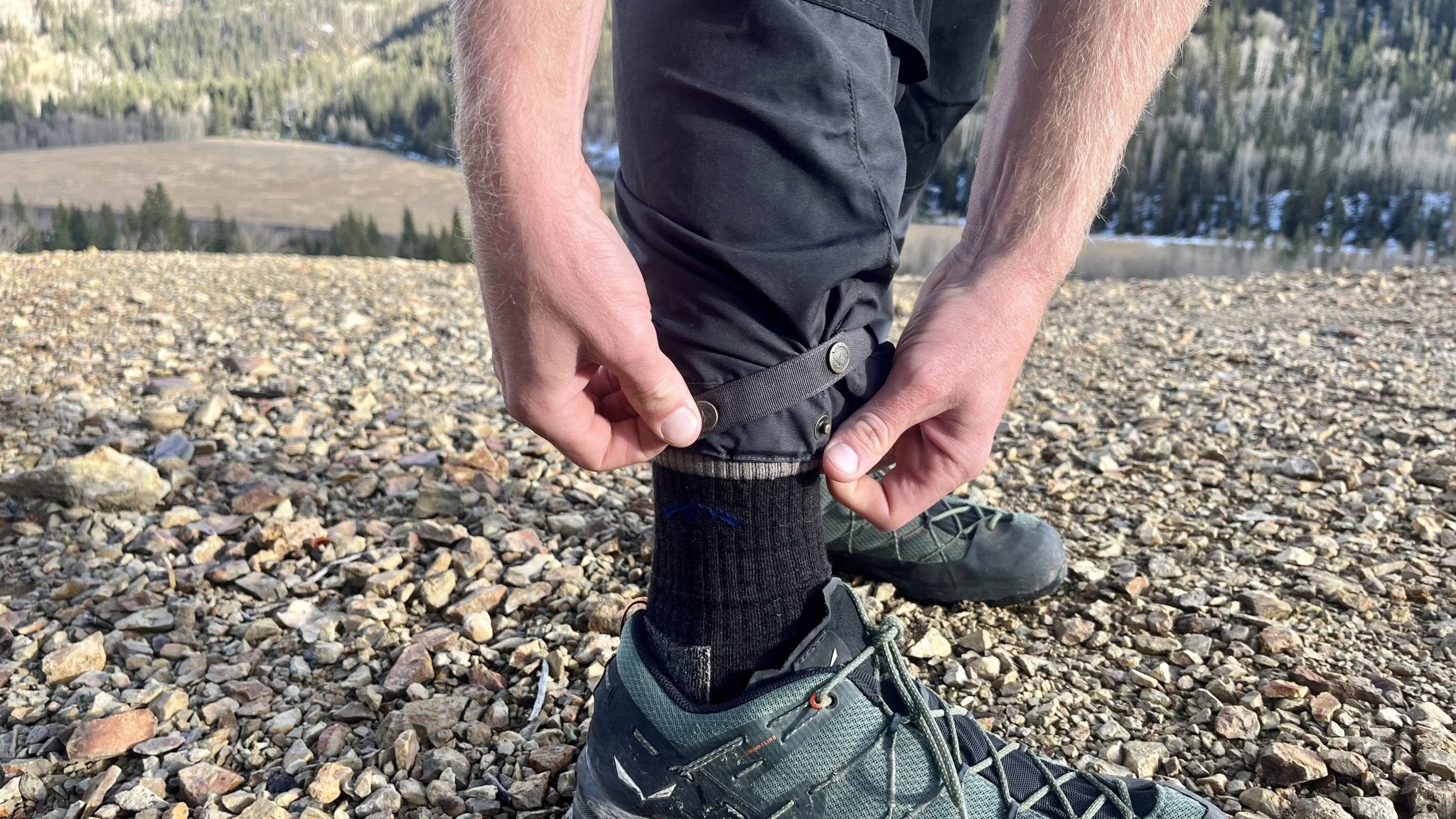 A close-up of the adjustable button strap on the cuff of Fjallraven Vidda Pro pants.