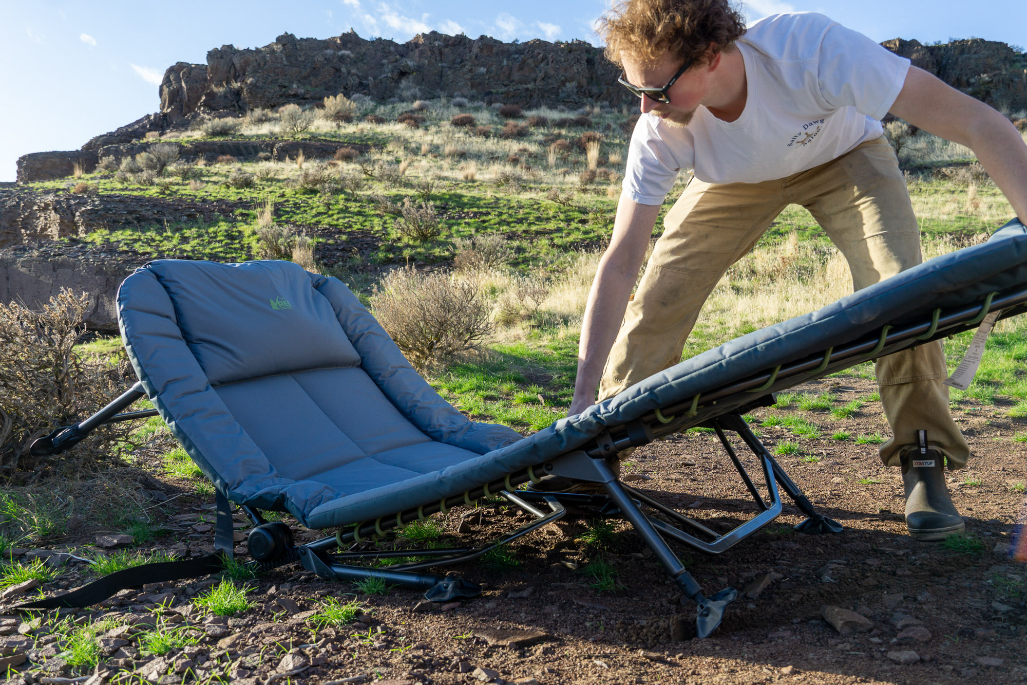 The author unfolding the REI Wonderland Comfort Cot at a campsite in Eastern Washington.