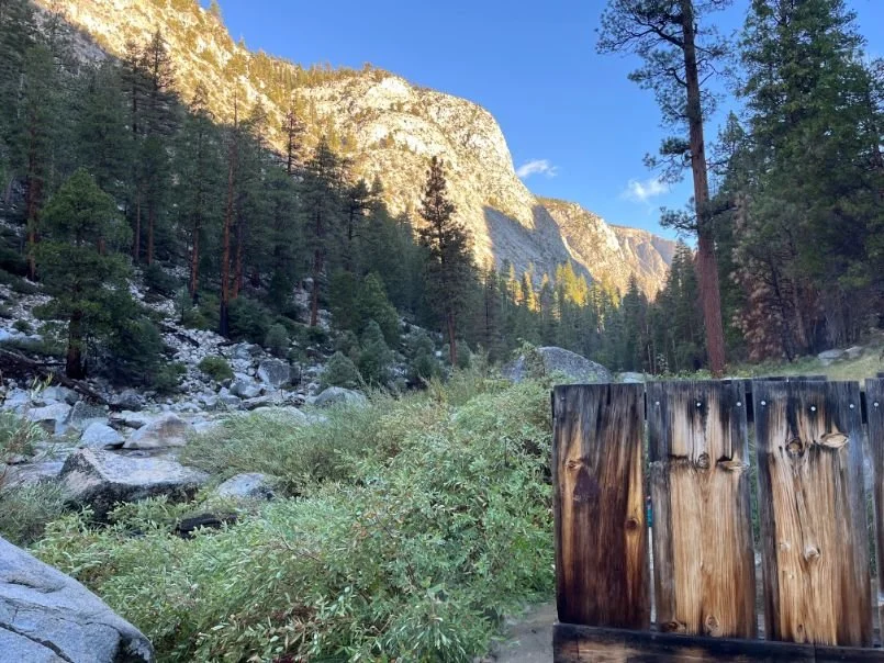A concrete soaking tub at Kern Hot Springs with a view of the surrounding canyon walls and river.