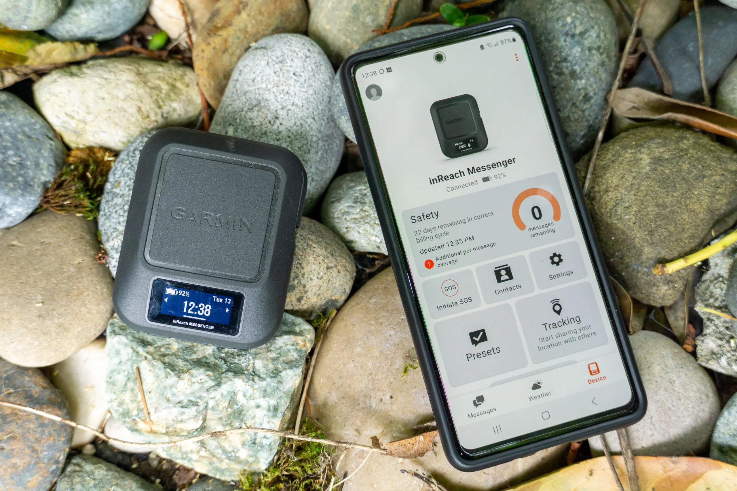 A smartphone showing the Garmin Messenger app interface next to its paired device.