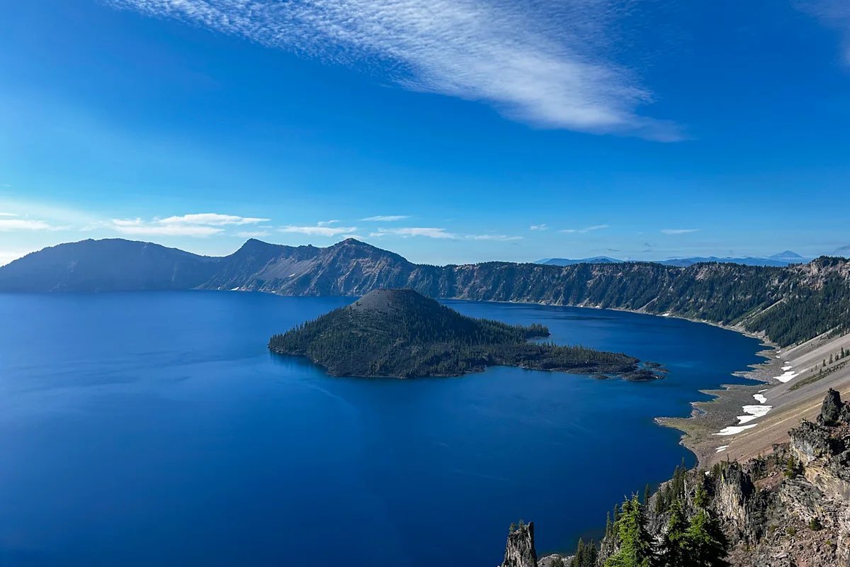 A high-angle view of the deep blue water and crater walls of Crater Lake National Park.