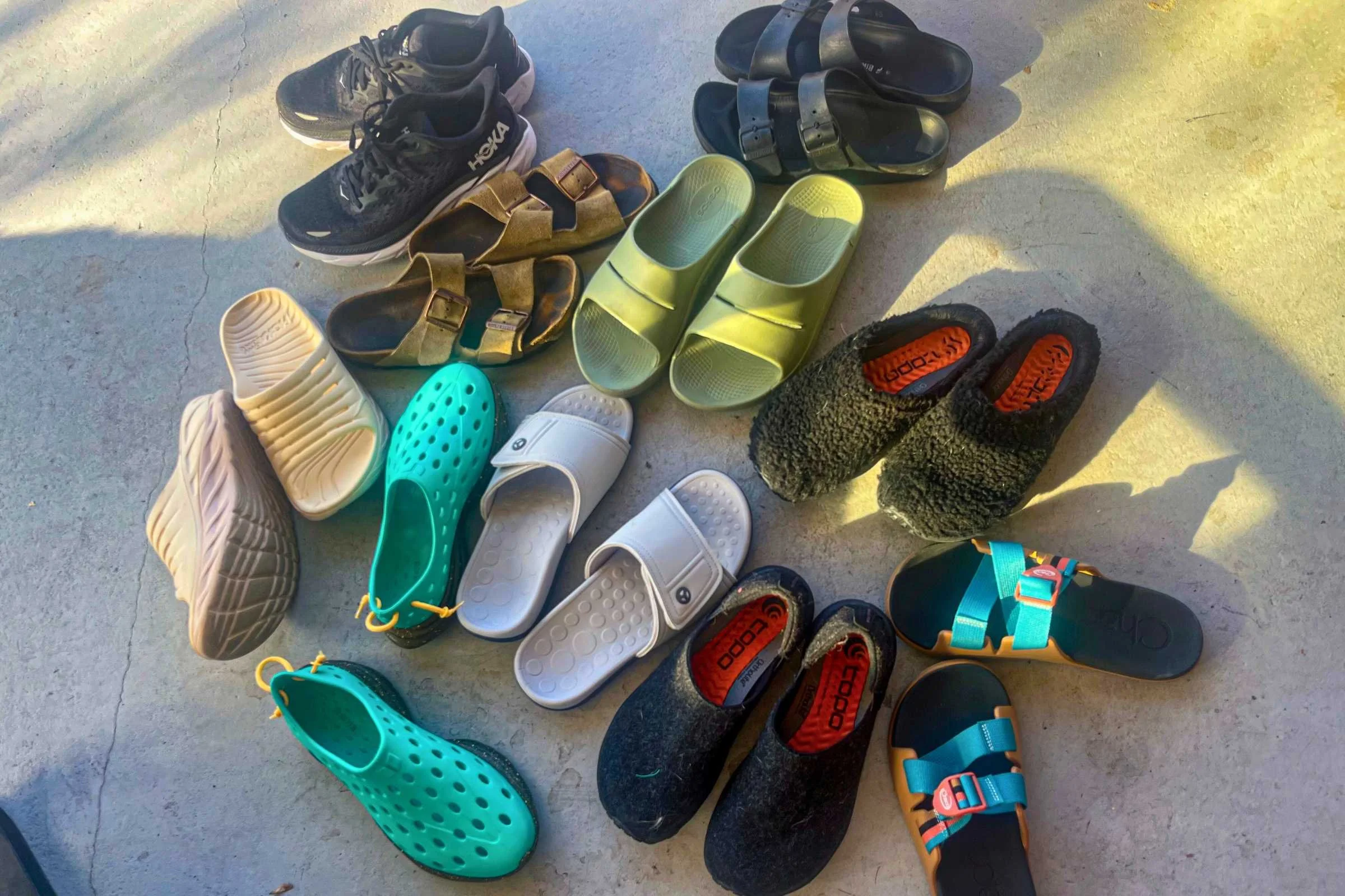 OOFOS recovery slides placed among a group of other performance recovery footwear during a comparison test.