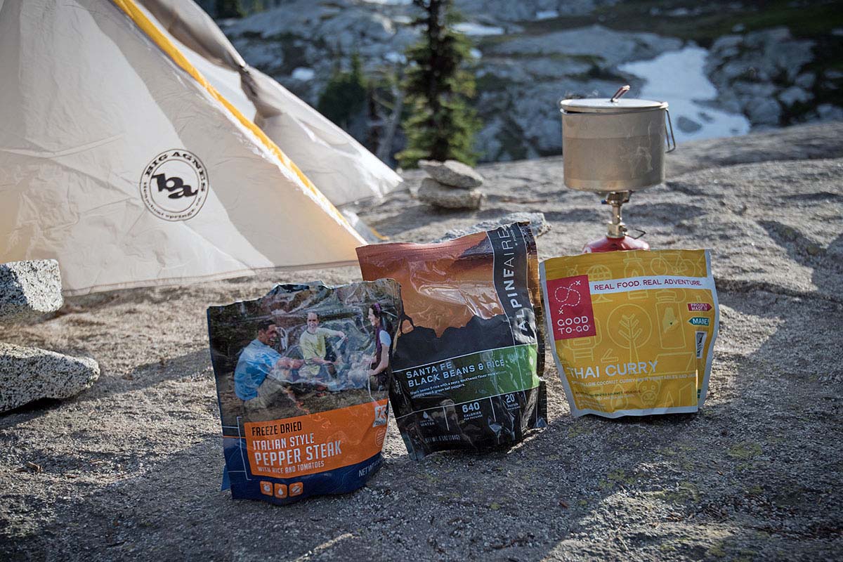A comparison photo of two backpacking meals placed side-by-side to highlight differences in caloric density.