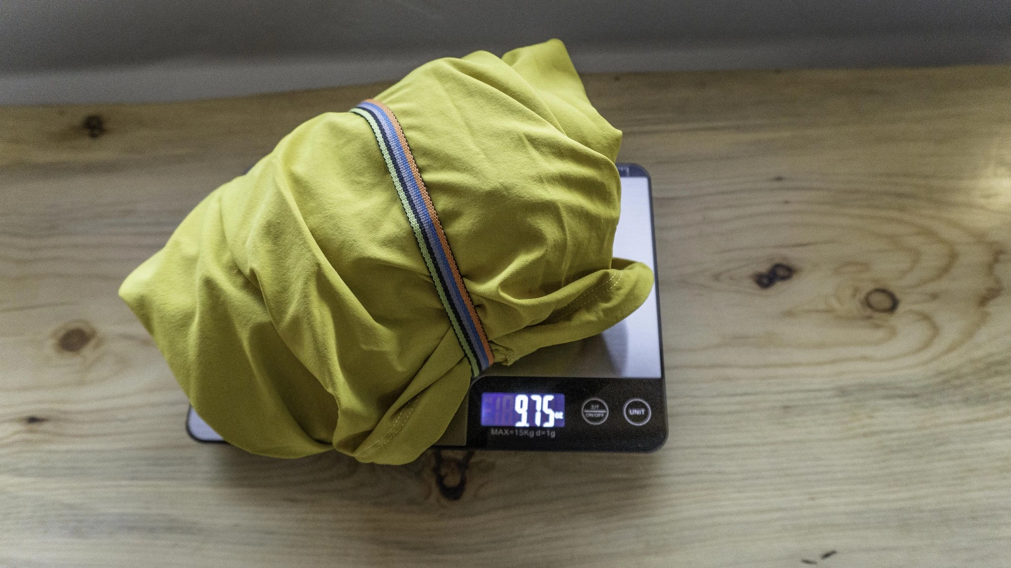 A person holding a packable, lightweight softshell jacket.