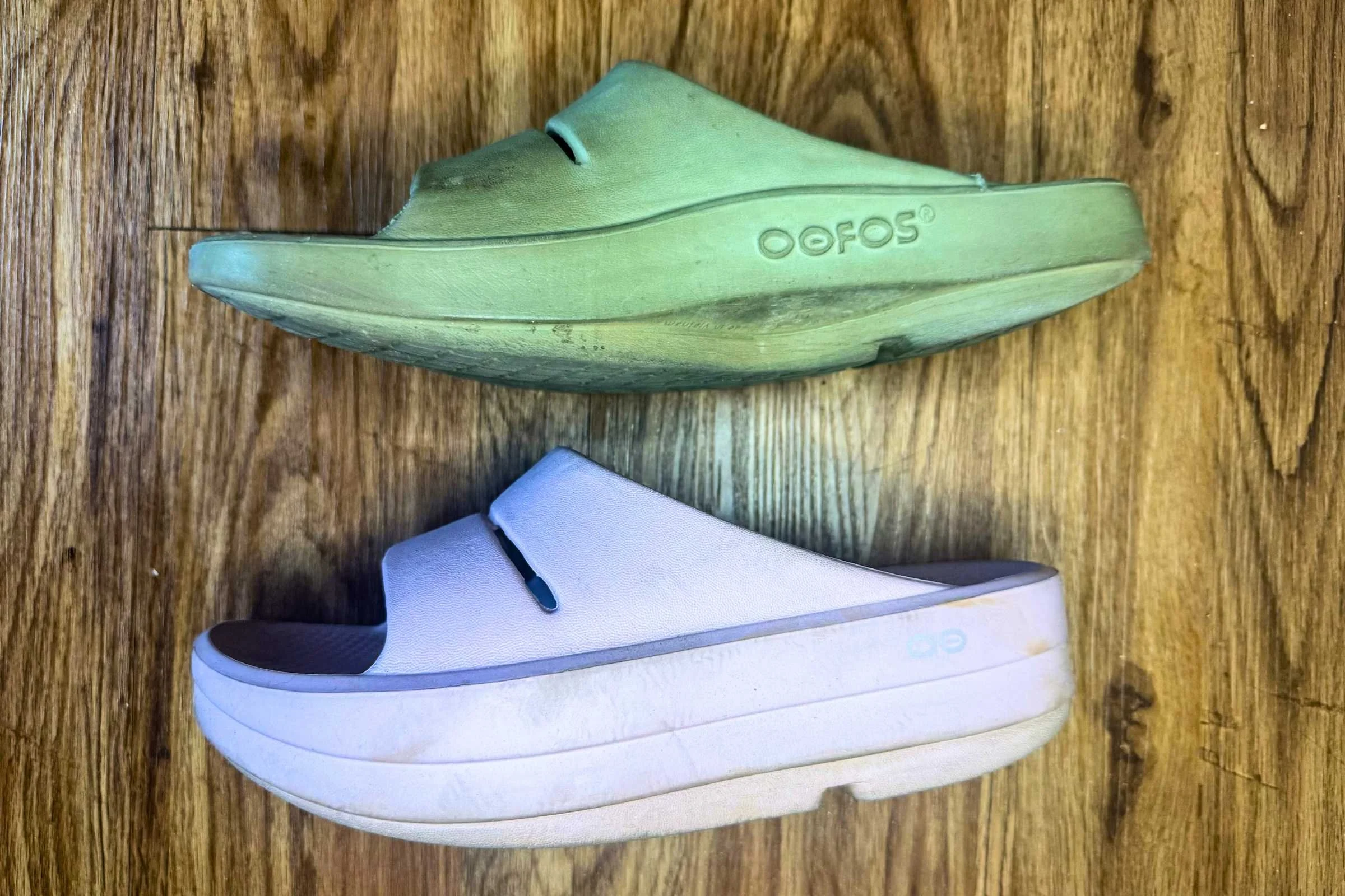 A side-by-side comparison showing the OOFOS OOmega slide versus the standard OOahh slide.