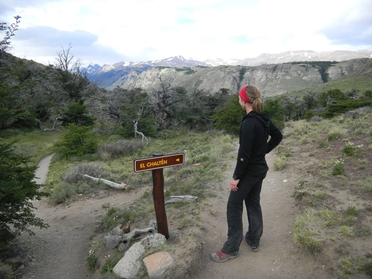 A hiker wearing a midweight fleece jacket on a trail during a cool day.