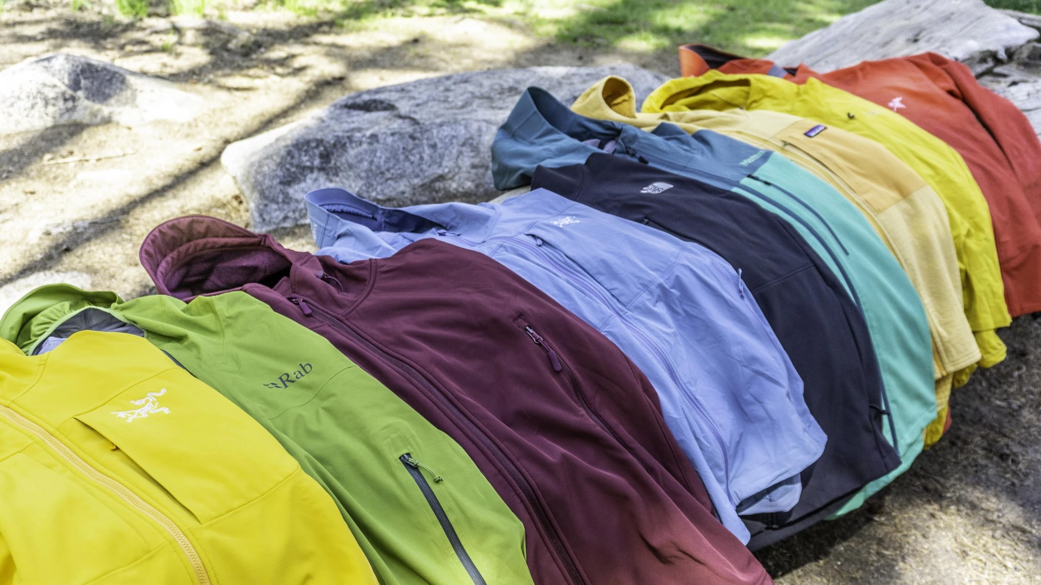 A collection of different men's softshell jackets in various colors and designs.