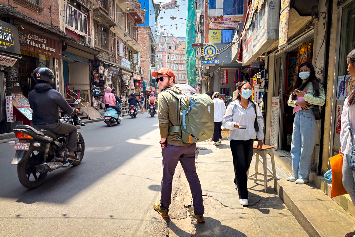A man wearing Bluffworks Envoy chinos while walking through the streets of Kathmandu.