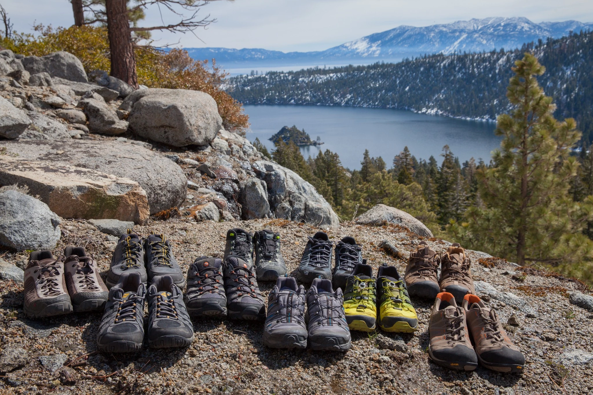An assortment of various hiking shoes and boots side by side.