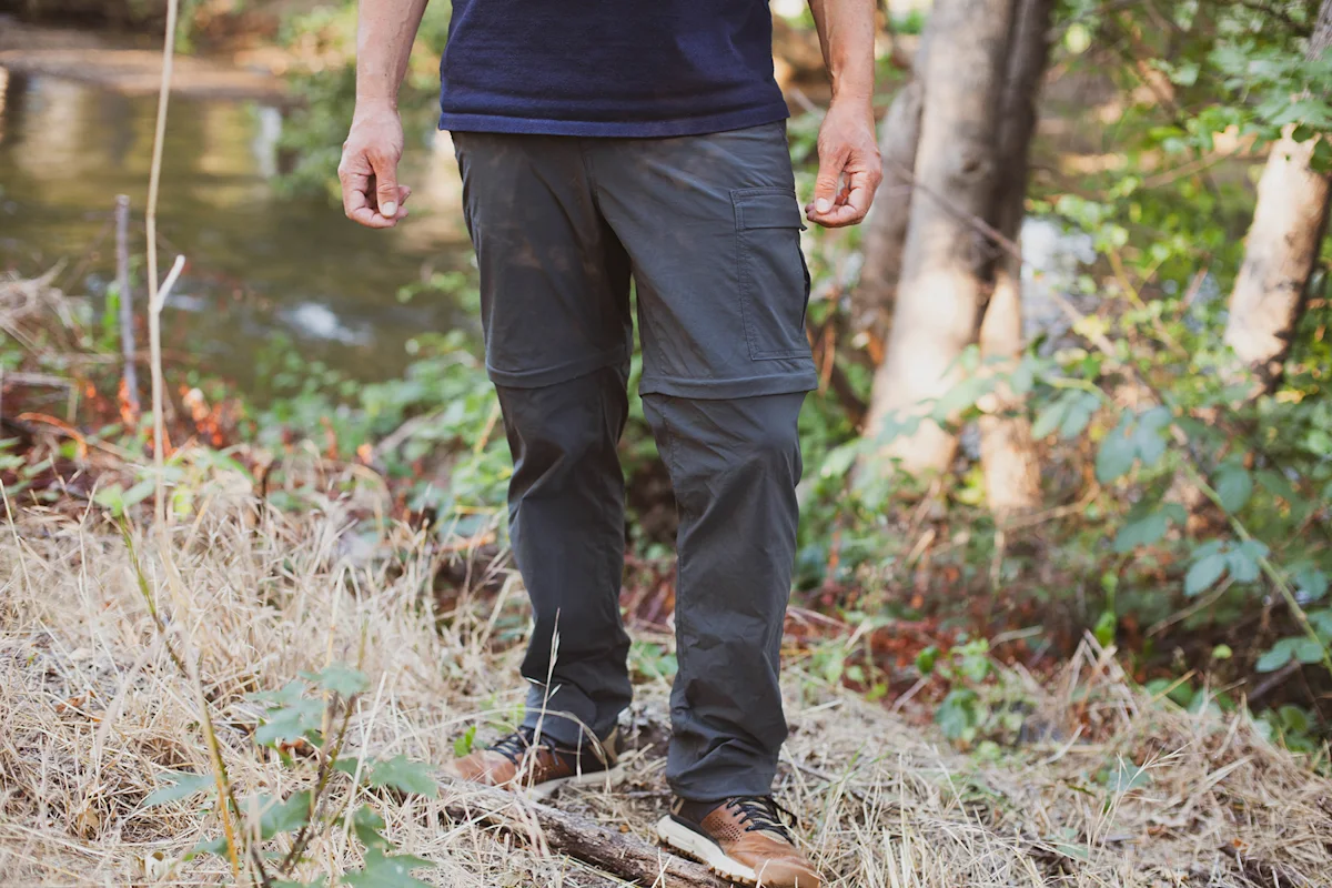 A man wearing versatile, neutral-colored hiking pants suitable for travel and trekking.