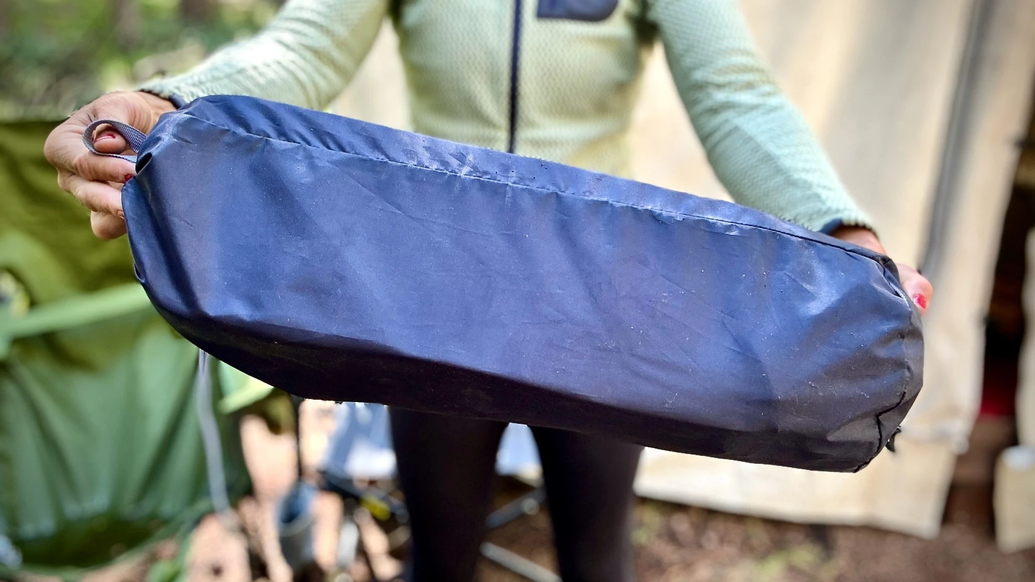 Close-up of a lightweight collapsible camping chair with an aluminum frame and breathable fabric.