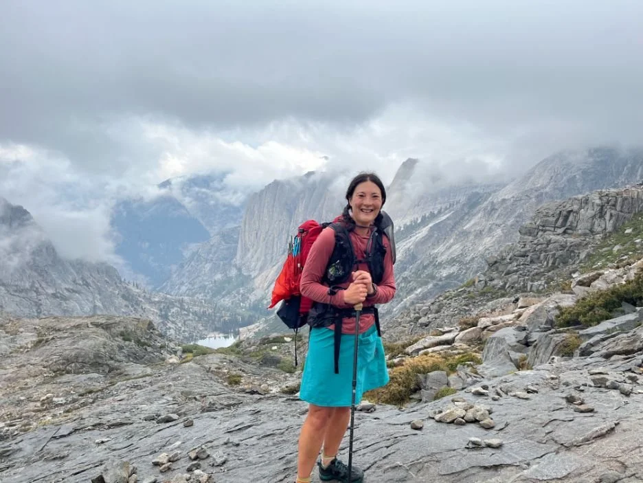 A hiker ascending a rocky path at Kaweah Gap during a rainy day.
