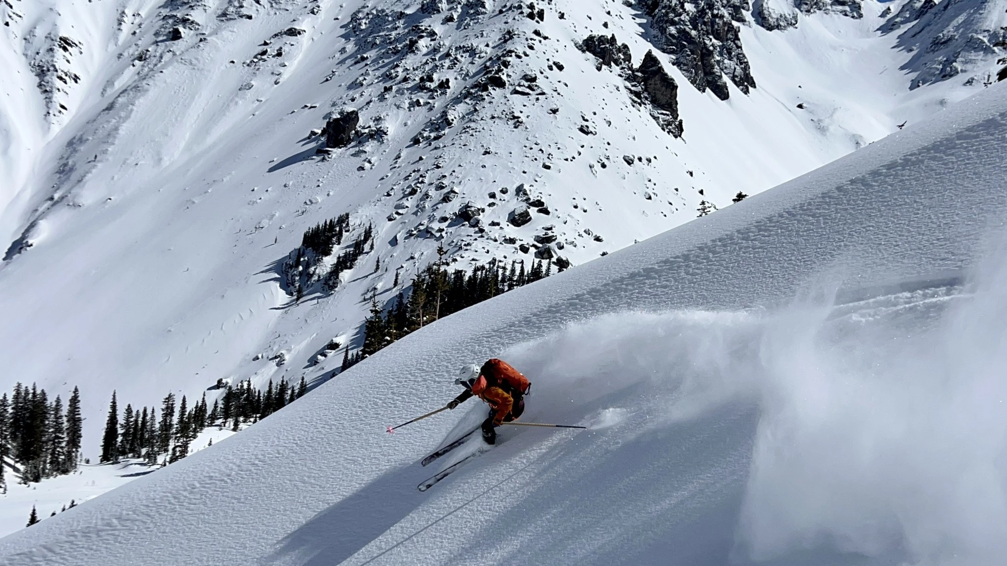A backcountry skier on an ascent wearing a medium-capacity avalanche backpack suitable for a full day of touring.