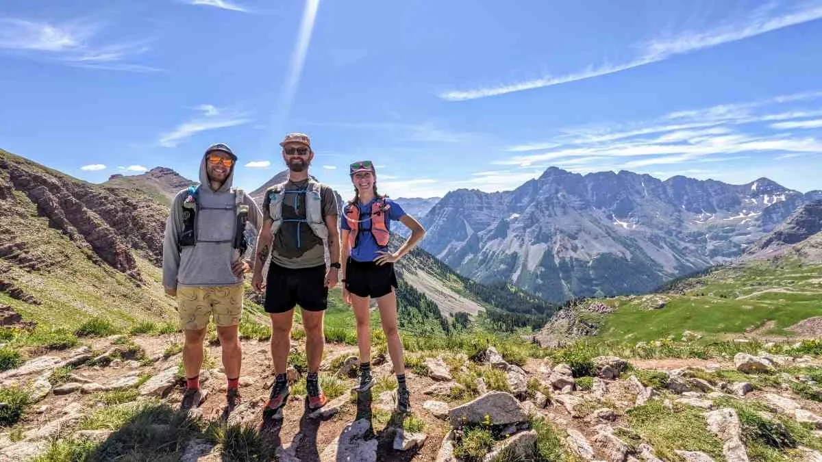 A trail runner in lightweight gear traversing a high-altitude ridge line during a clear morning on the Four Pass Loop.