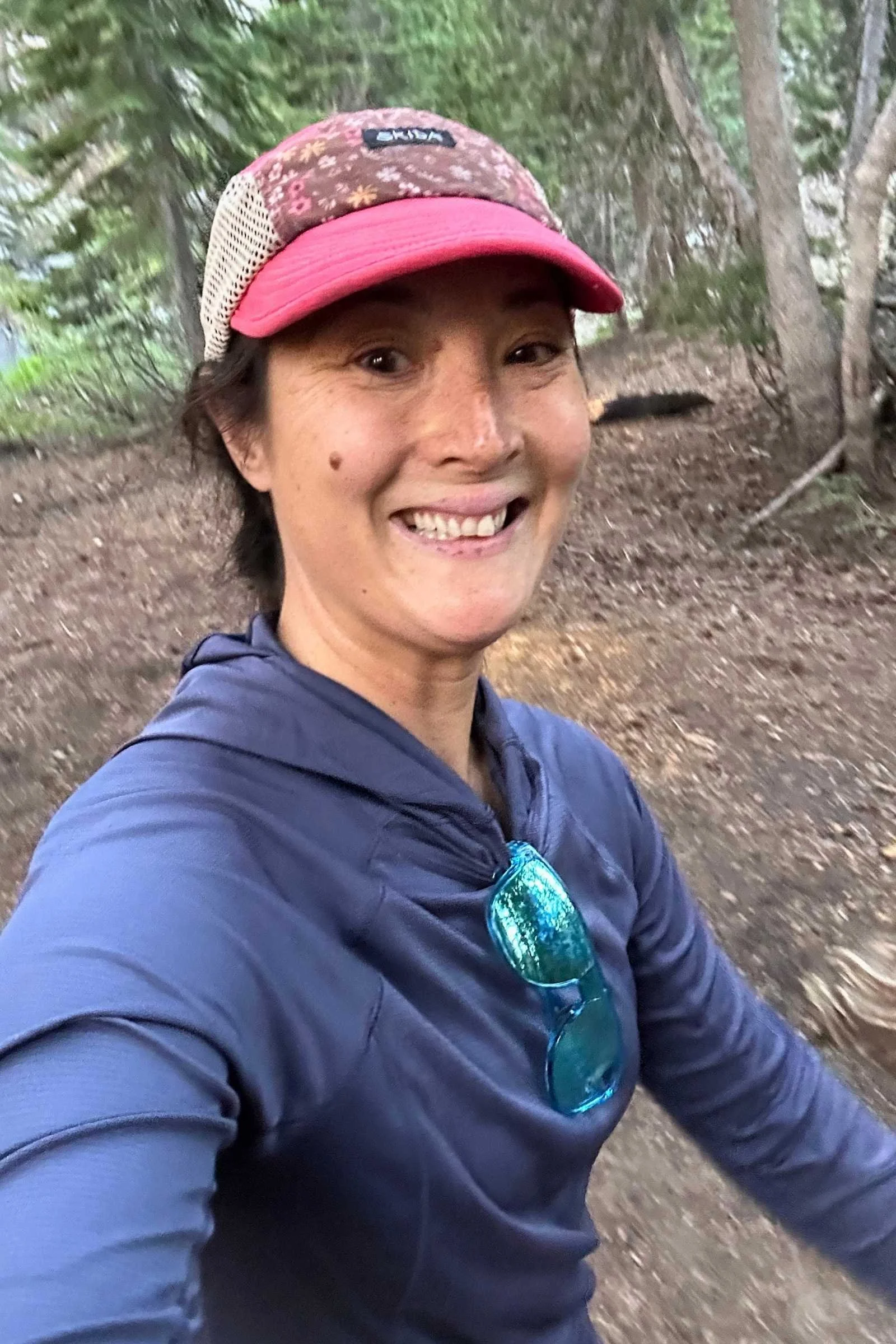 A hiker moving quickly uphill wearing the REI Flash Shade sun hoodie.