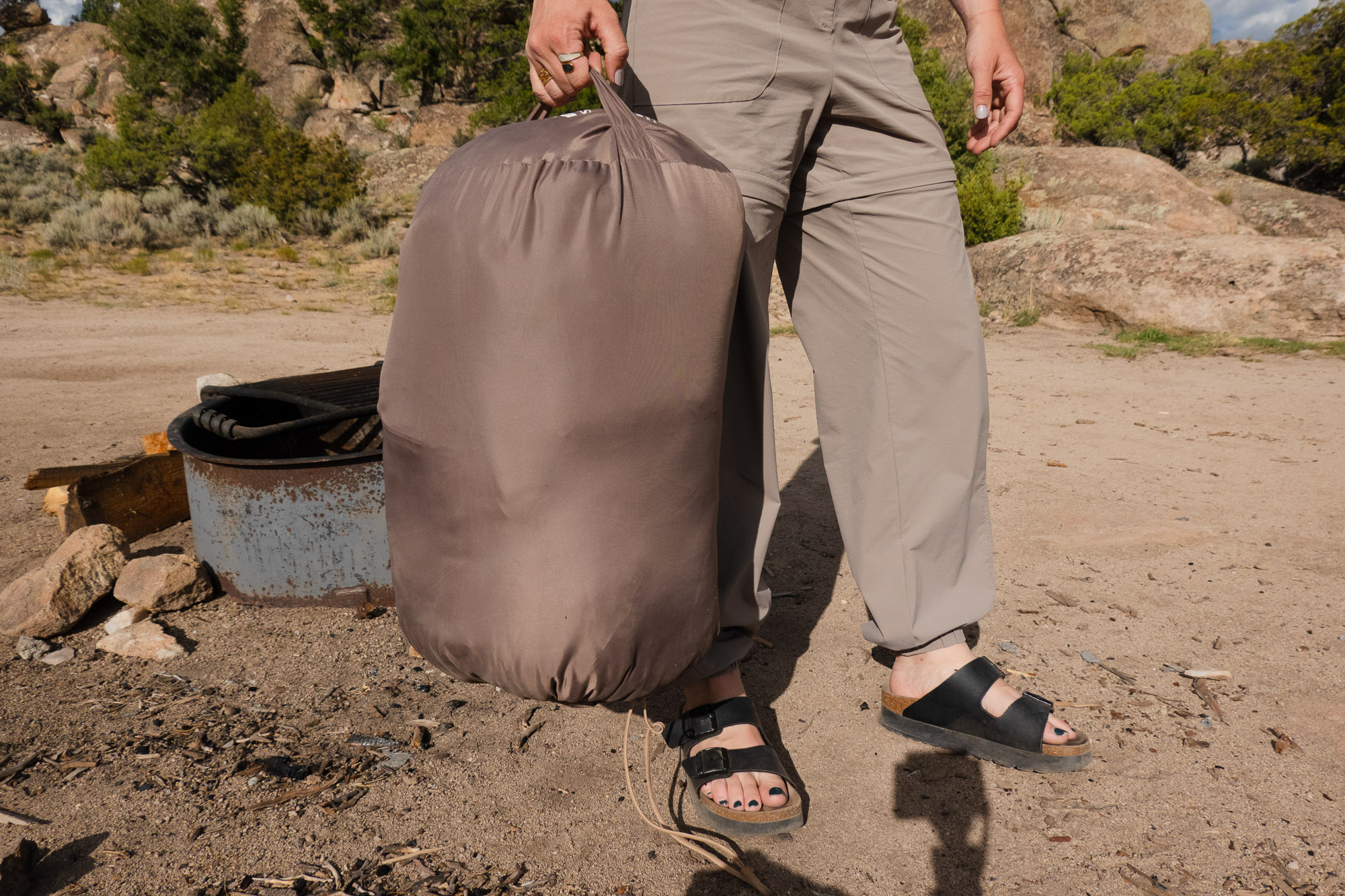 The author holding the large stuffed sack of the REI Siesta sleeping bag.