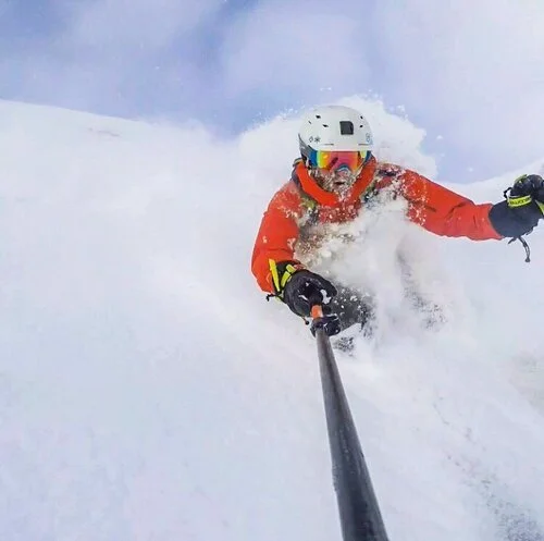 First-person perspective selfie of a skier in motion.