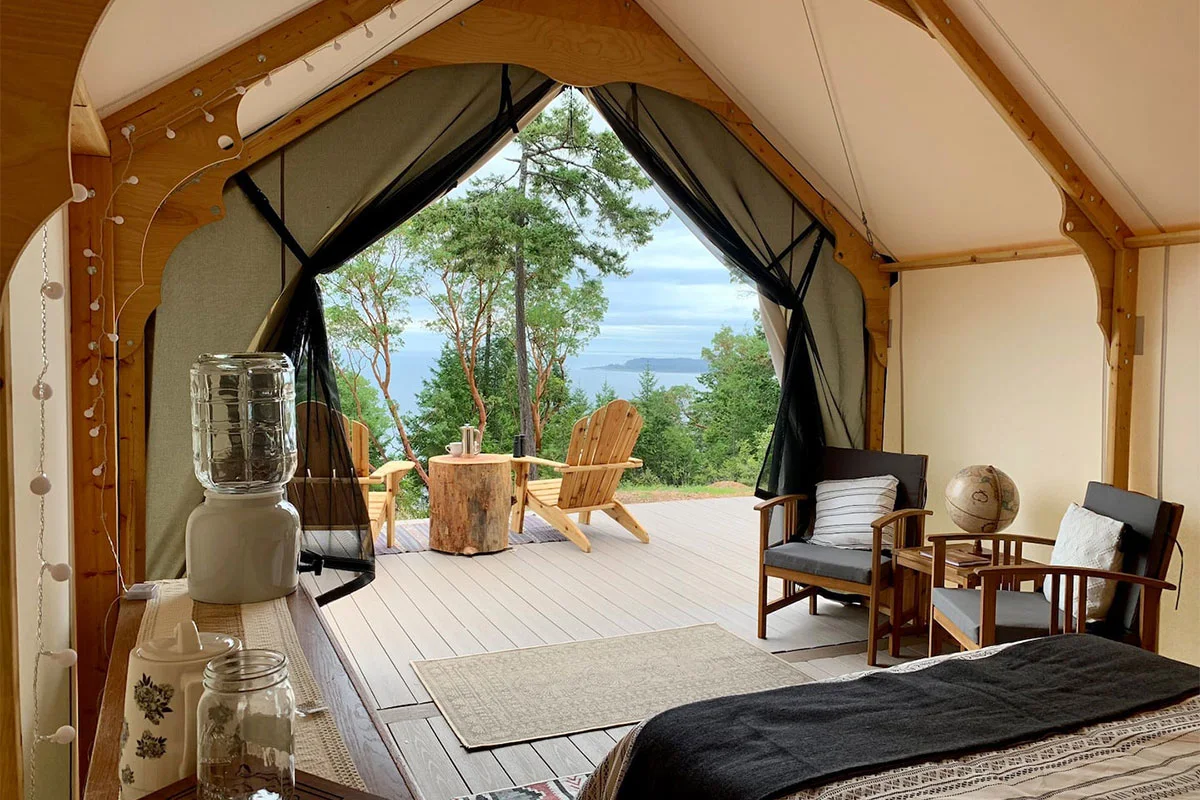 Interior of a luxury glamping tent in Clallam County featuring a comfortable bed and high-end decor.
