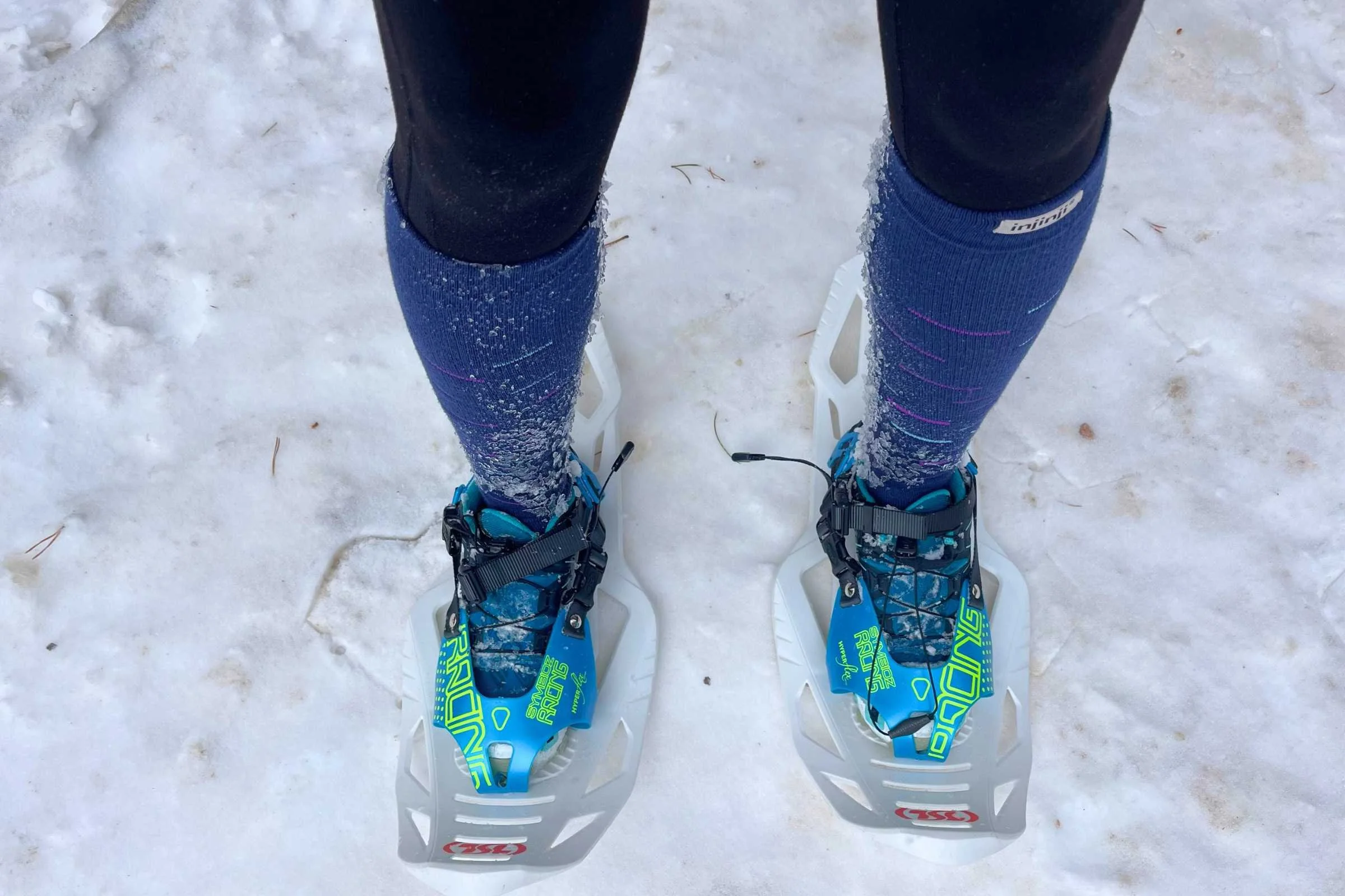 A pair of TSL Symbioz Hyperflex racing snowshoes resting on the snow.