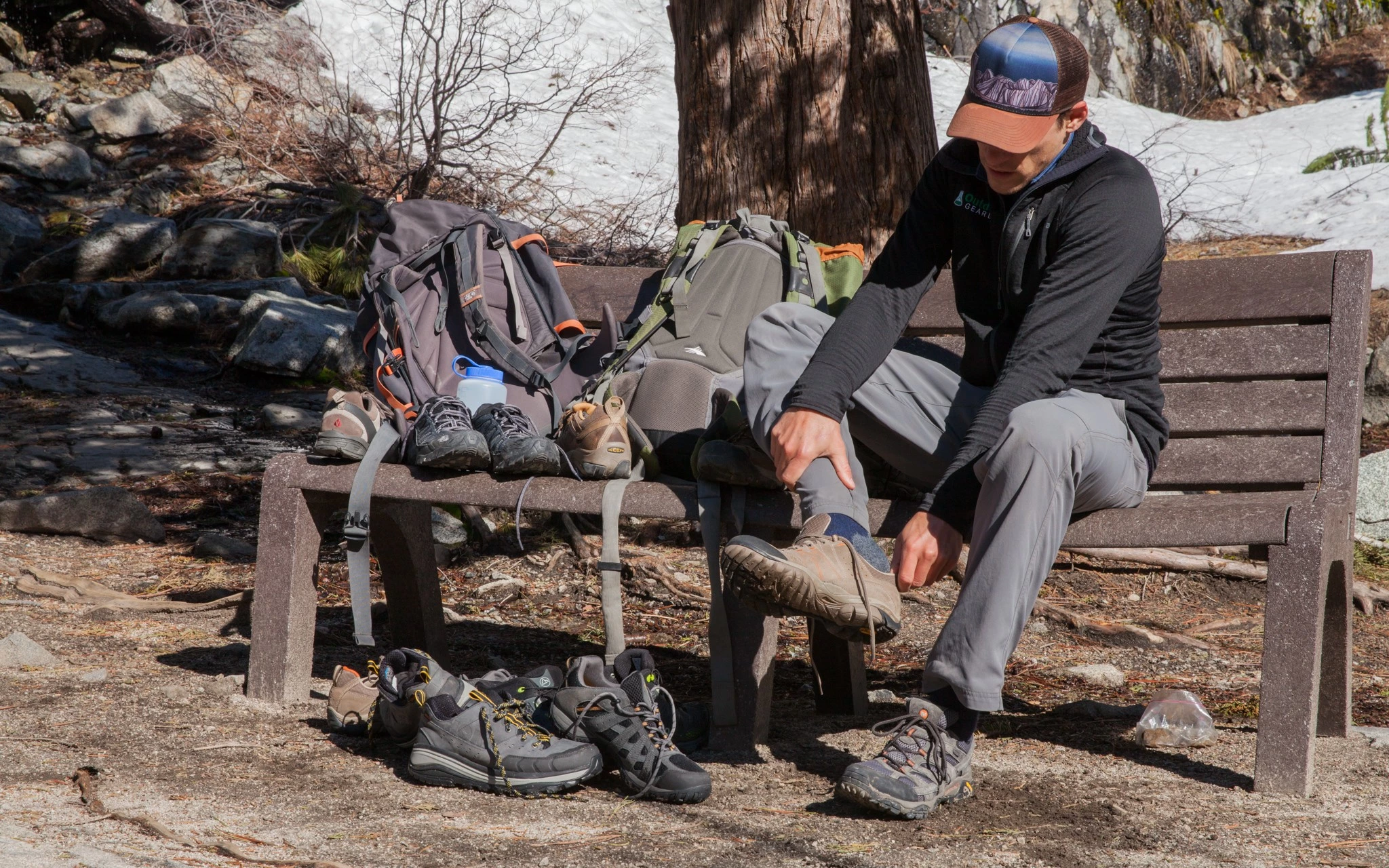 A hiker adjusting the fit of their footwear on the trail.