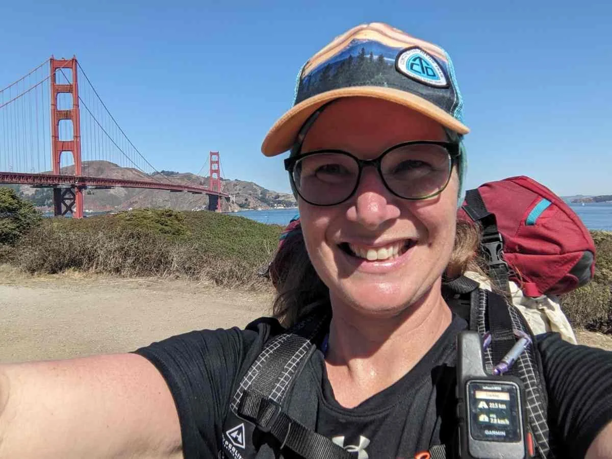 The author walking toward the Golden Gate Bridge carrying a backpack.