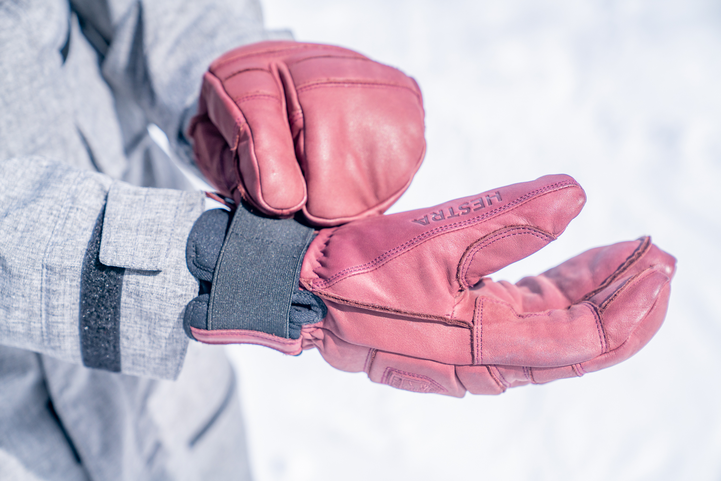 A person wearing high-quality leather three-finger lobster-style ski gloves.