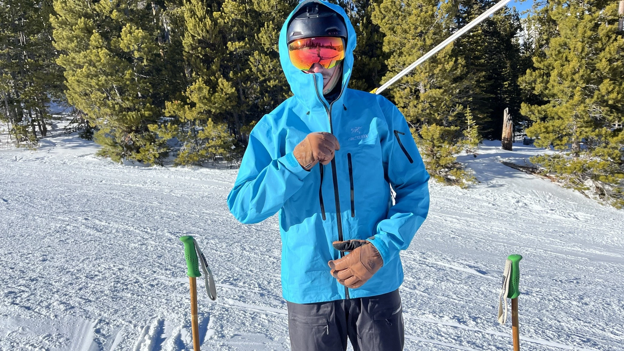 A person wearing a hardshell jacket in snowy conditions to show weather protection.