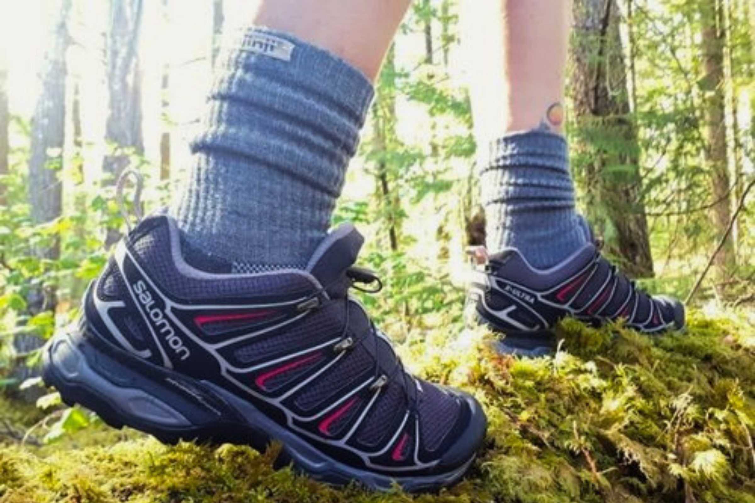 Side profile of a Salomon hiking shoe on a wooden surface showing its stable construction.