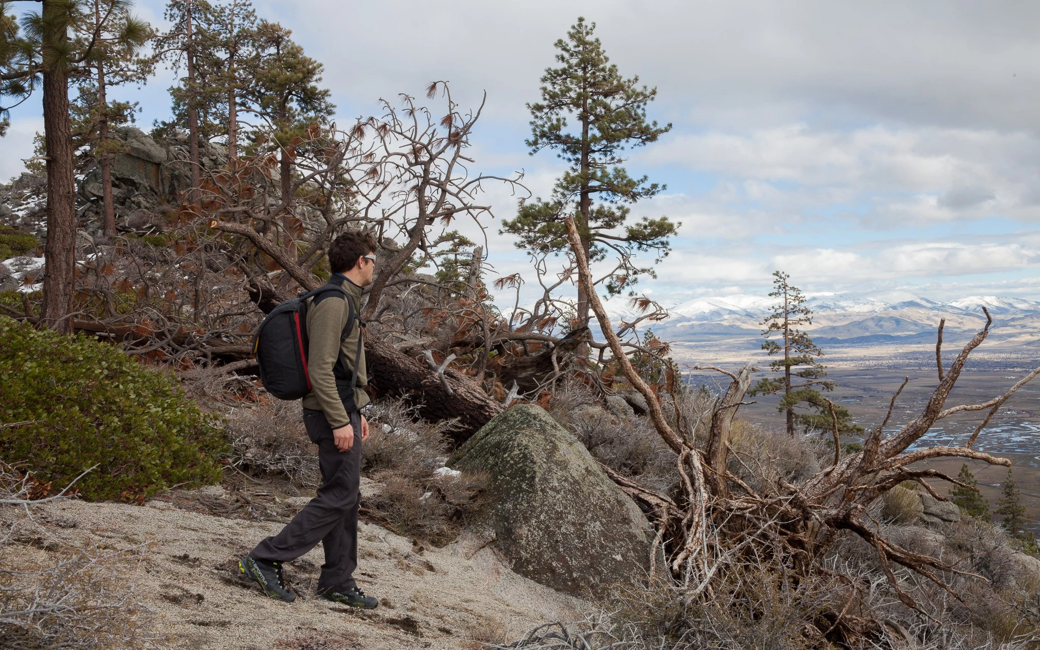 A hiker wearing low-cut hiking shoes carrying a small daypack.