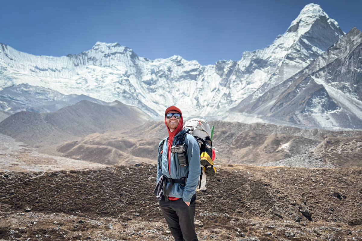 A hiker wearing a Black Diamond Alpenglow hoodie while trekking in the Himalayas.