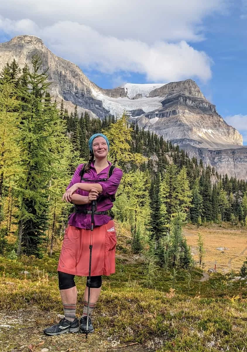 Bethany Hughes hiking on the Great Divide Trail in Banff, Canada, surrounded by mountains.
