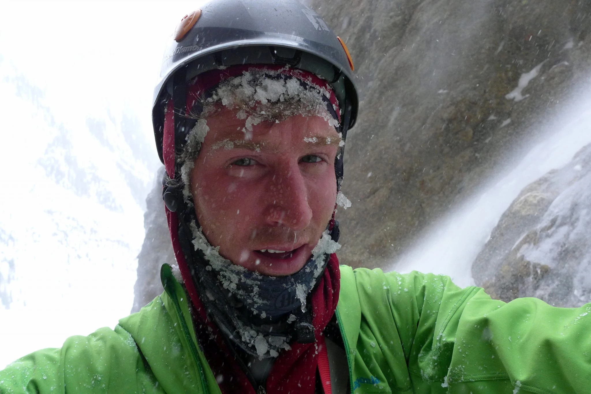 A person in a light rain jacket looking cold and wet in rainy conditions.