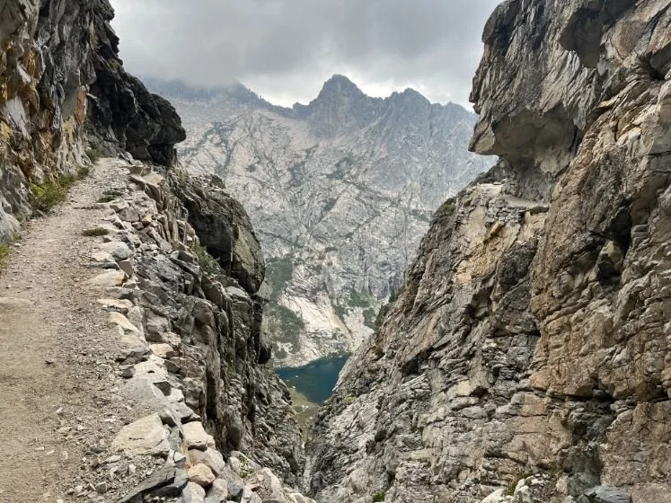 A section of the High Sierra Trail carved into a steep granite cliff, showing the narrow catwalk path.
