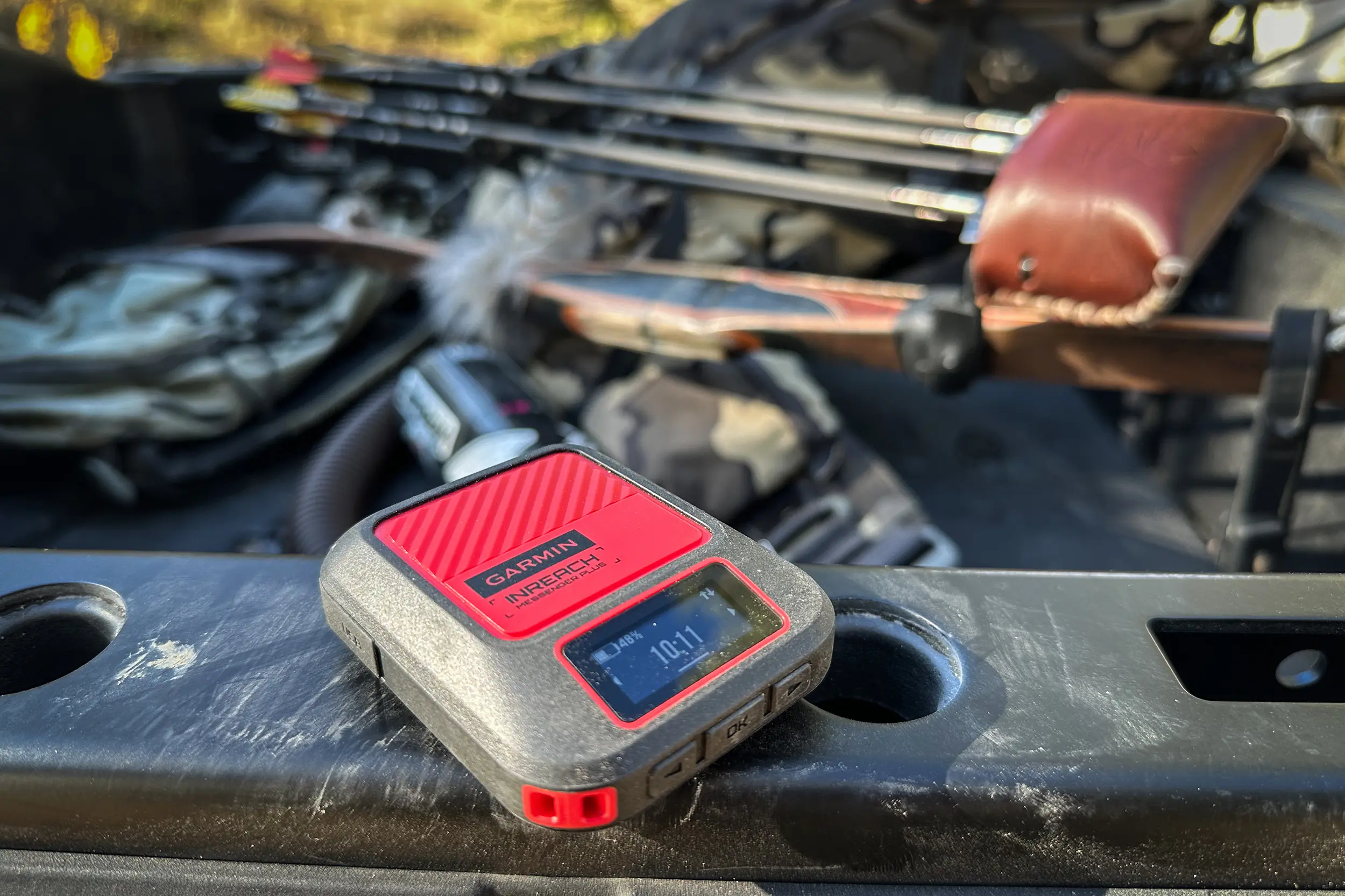 Hands operating a Garmin inReach Messenger Plus in a cold, wintry setting.