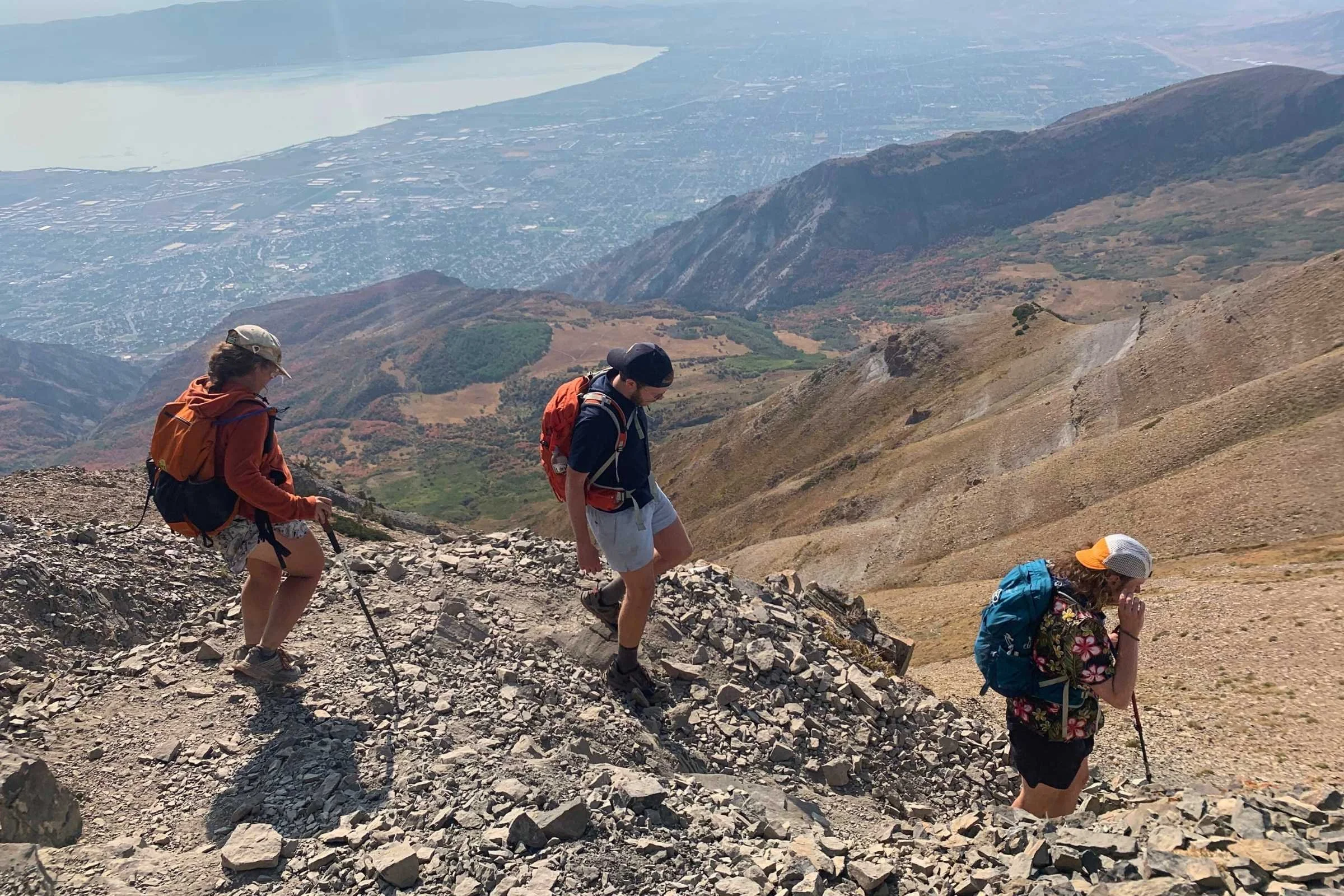Several hiking backpacks leaning against rocks in a wilderness area during a break.
